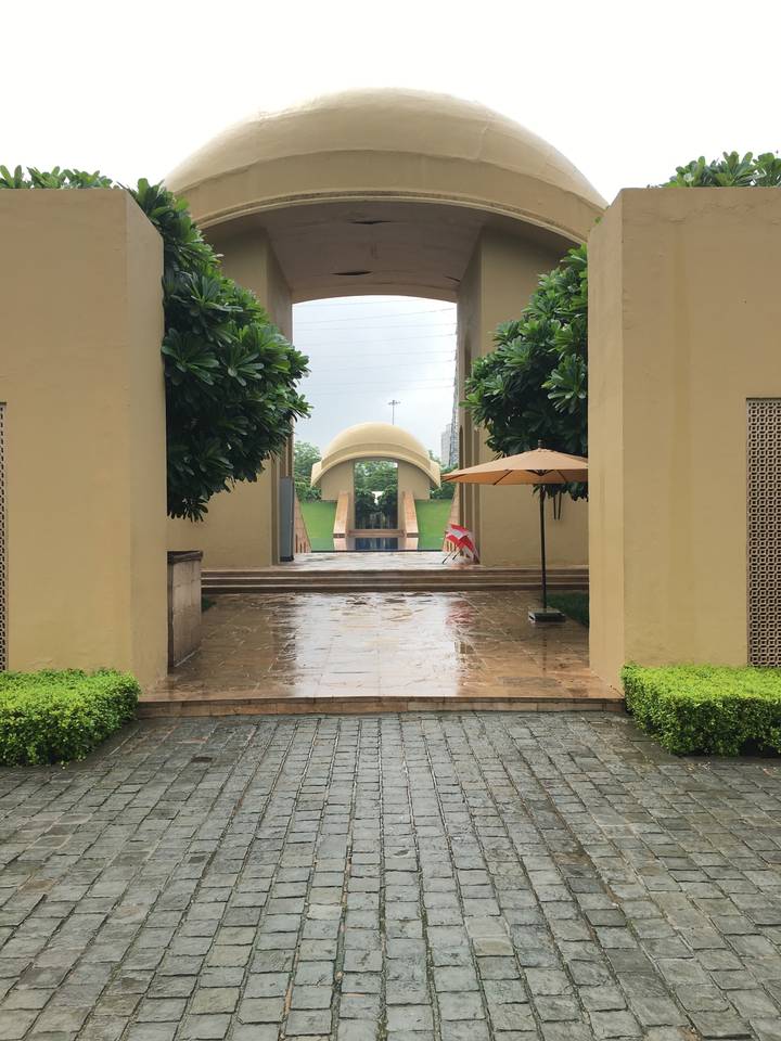 Sentier avec arcade structurée et arbres décoratifs.