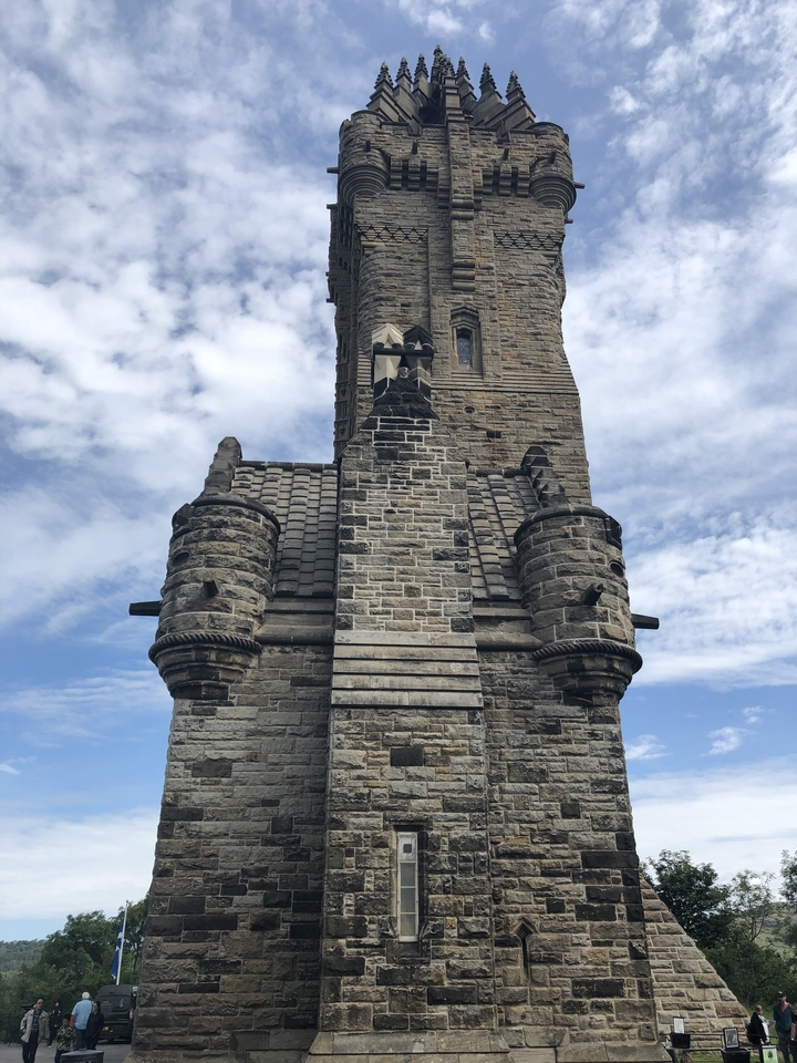 Tour de pierre avec créneaux sous un ciel partiellement nuageux