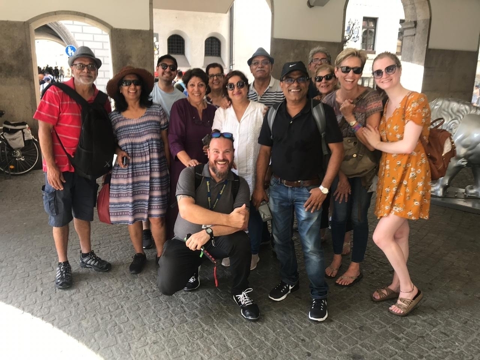 Un grand groupe de personnes prenant la pose ensemble dans un espace public.