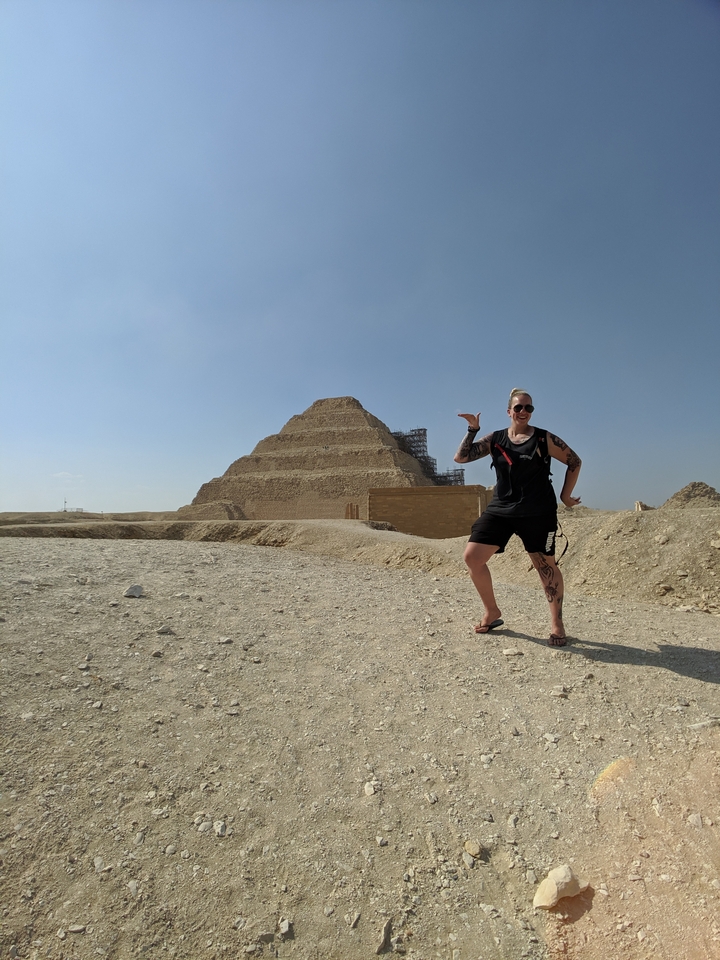 Person posing with a pyramid in the background.
