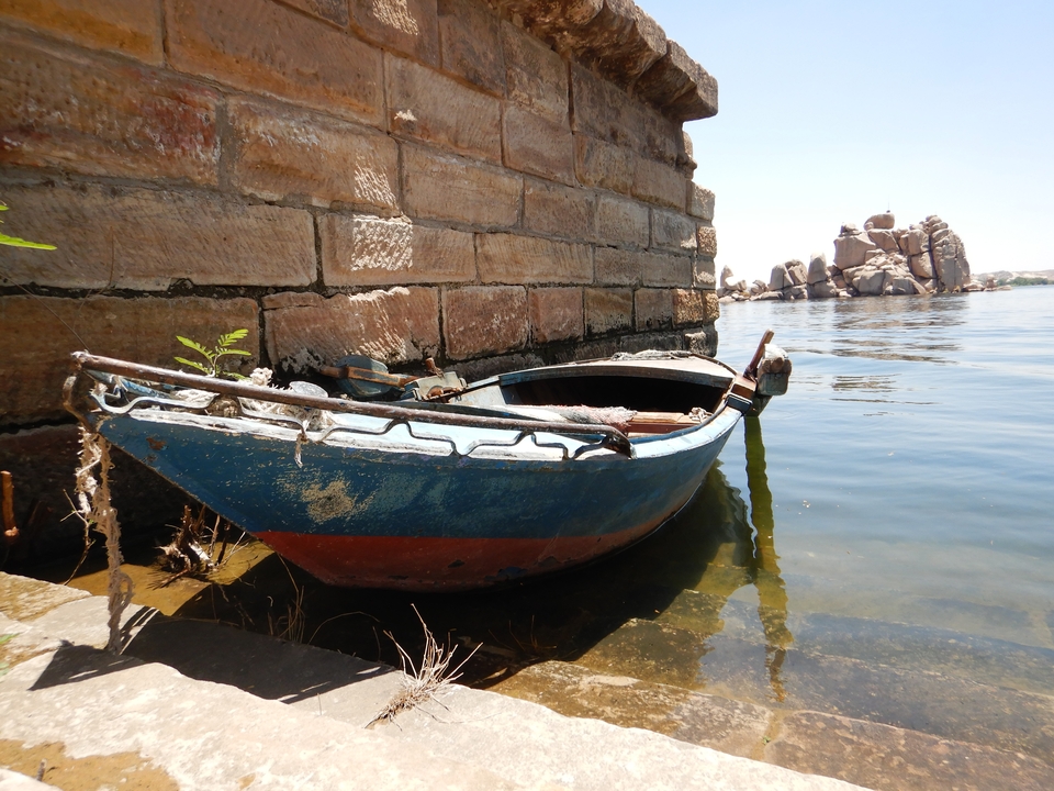 Old boat docked by a river.