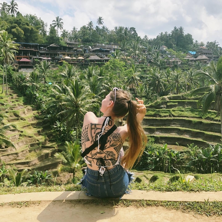 Woman posing in front of terraced rice fields.