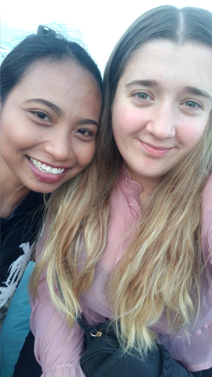 Selfie en gros plan de deux personnes souriantes.