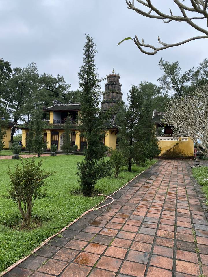 "Bâtiment vu à travers de grands arbres avec une architecture traditionnelle."