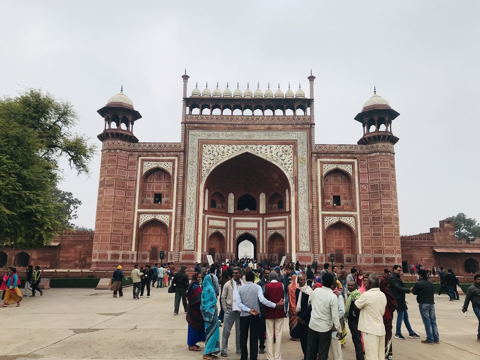 Grande porte ornementée avec des touristes.