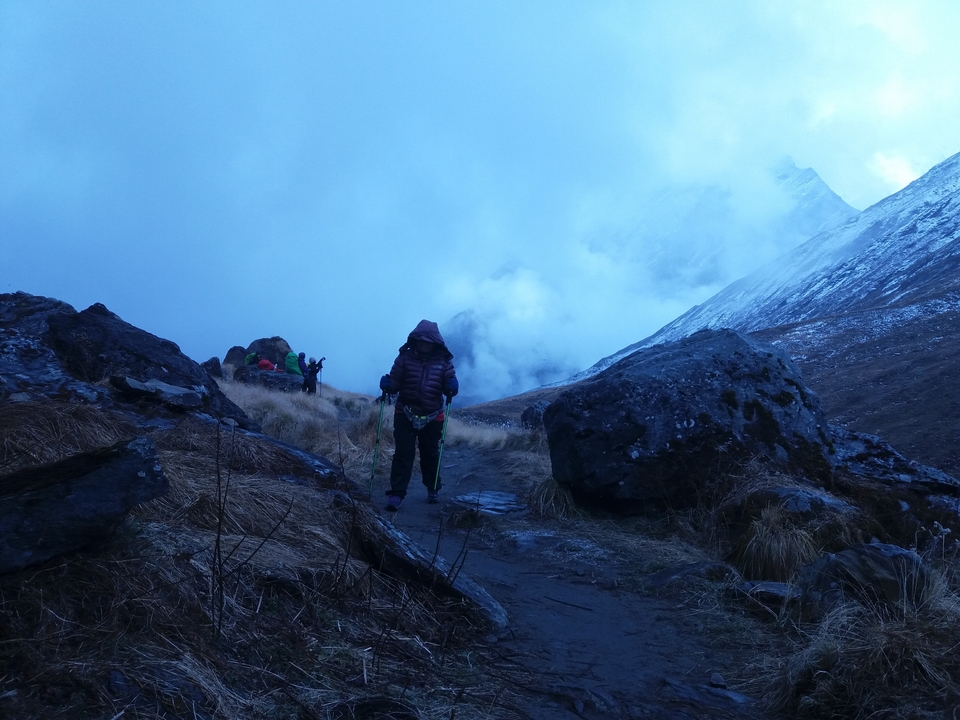 Des gens qui font de la randonnée le long d'un sentier de montagne brumeux.