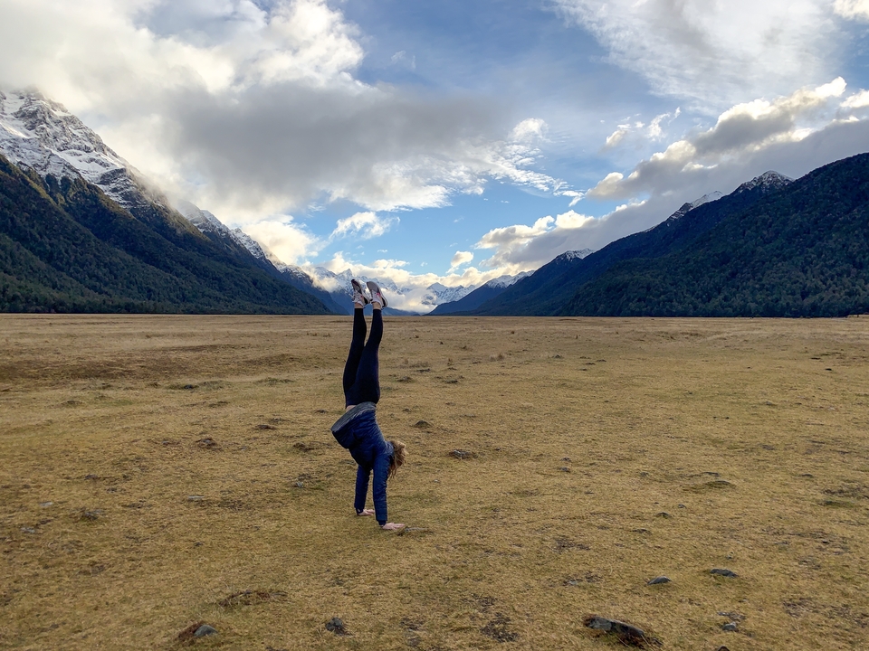 Personne faisant le poirier dans une large vallée.