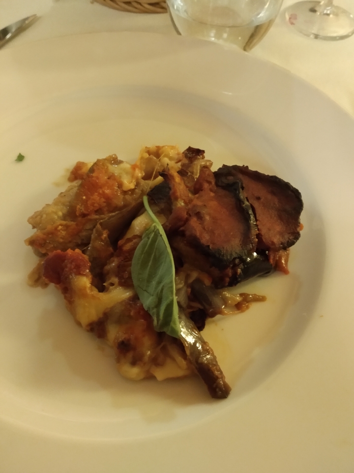 Gros plan d'un plat avec aubergine et basilic.