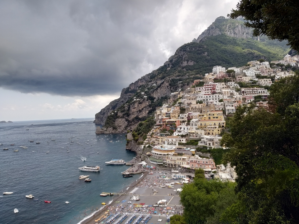 Paysage urbain côtier pittoresque avec des bâtiments colorés sur une colline escarpée.
