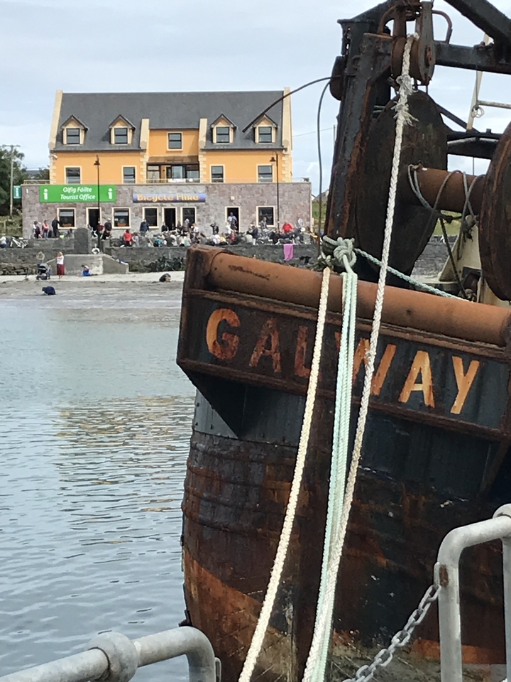 Close-up of a ship with 'GALWAY' written on it with a crowd in the background.