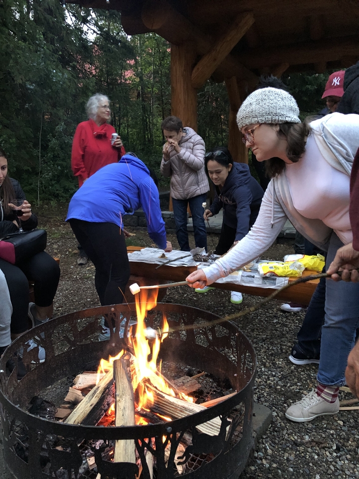 Des gens rassemblés autour d'un foyer, grillant des guimauves.