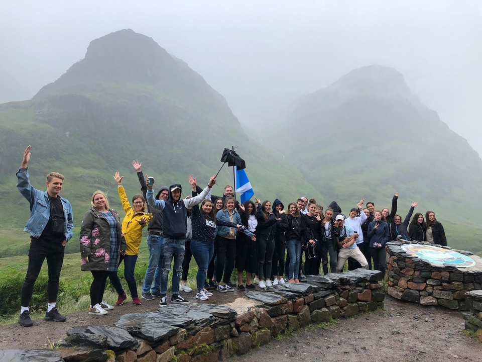 Groupe de personnes avec des montagnes dans l'arrière-plan brumeux.