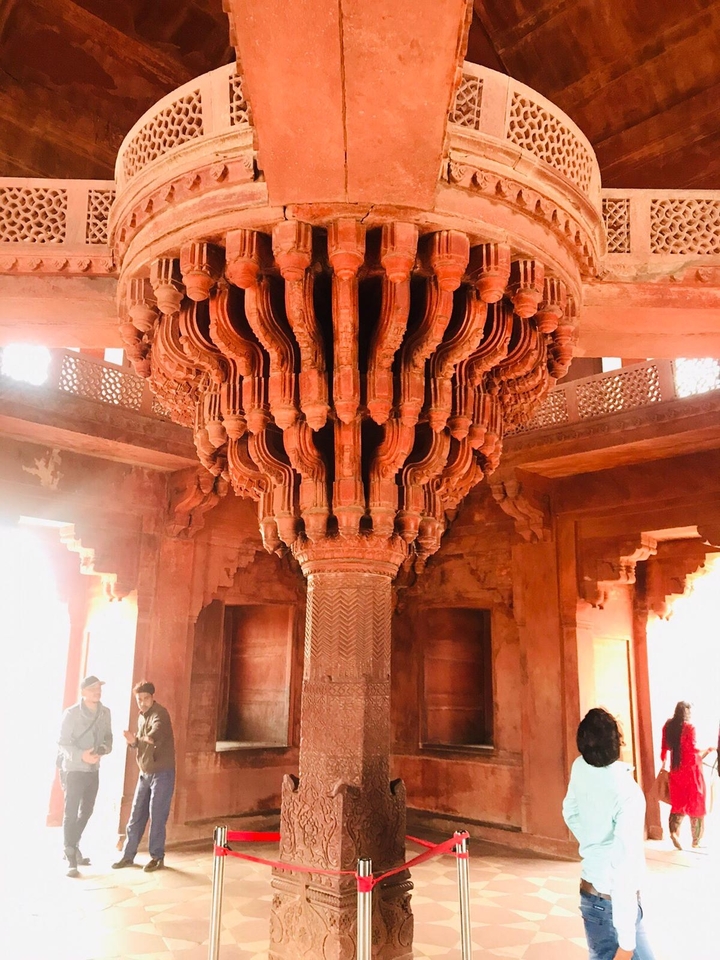 Pilier orné avec des sculptures complexes à l'intérieur d'un bâtiment ancien.