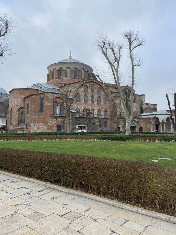 Grande église historique avec façade en brique et pelouse devant.
