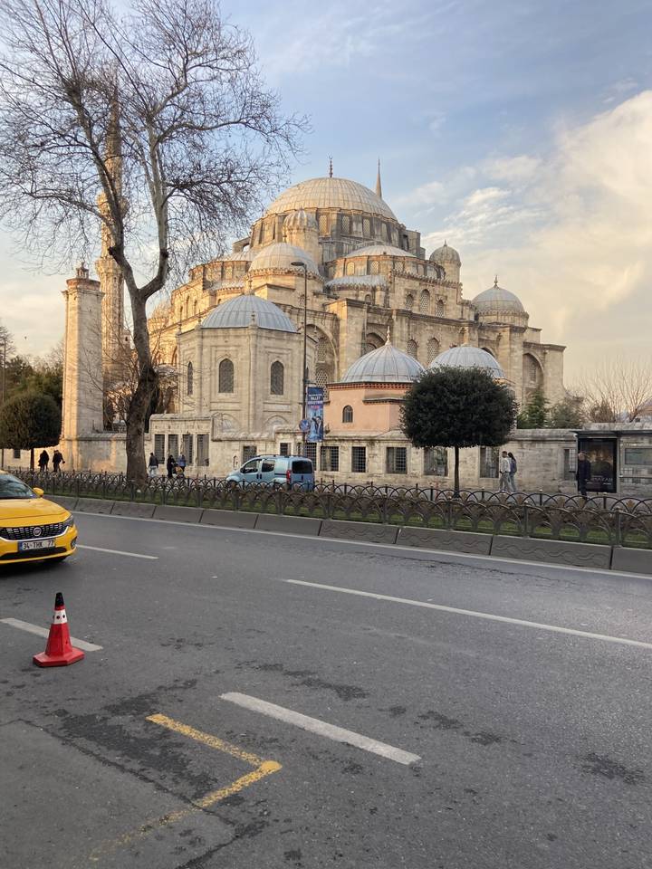 Mosquée historique remarquable avec une rue animée devant.