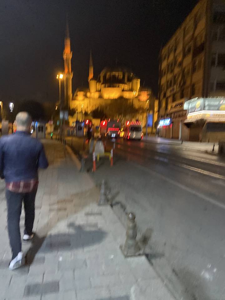 Vue de rue floue la nuit avec une mosquée en arrière-plan.