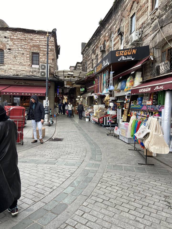 Rue de marché animée avec des boutiques et des piétons.