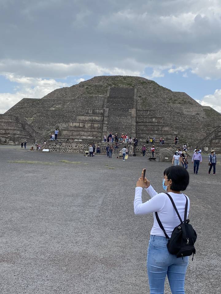 Des touristes prenant des photos de grandes ruines de pierre.