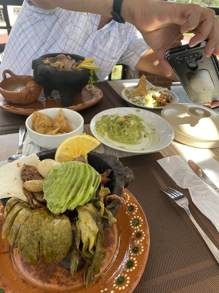 Dressage de table avec des assiettes de nourriture et du guacamole.