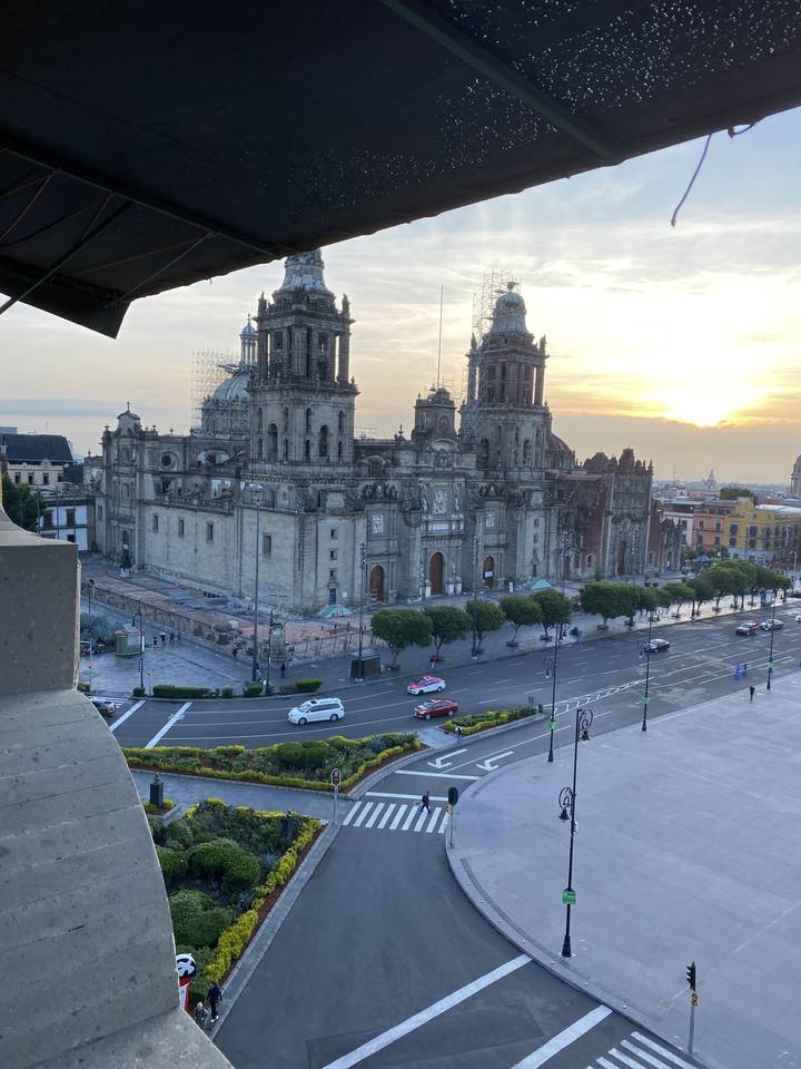 Bâtiment historique sur une place de ville au coucher du soleil.