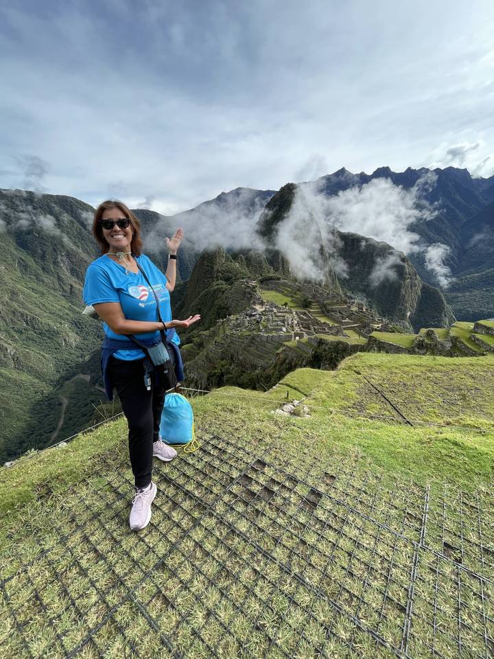 Femme posant avec le Machu Picchu en arrière-plan.