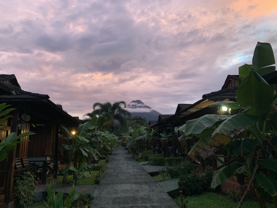 Vue panoramique d'un sentier d'hébergement avec une montagne volcanique au loin.