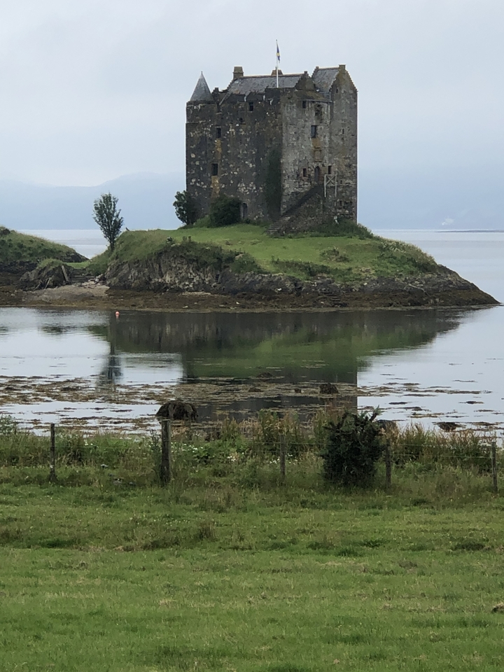 Structure semblable à un château sur une petite île dans une étendue d'eau calme.