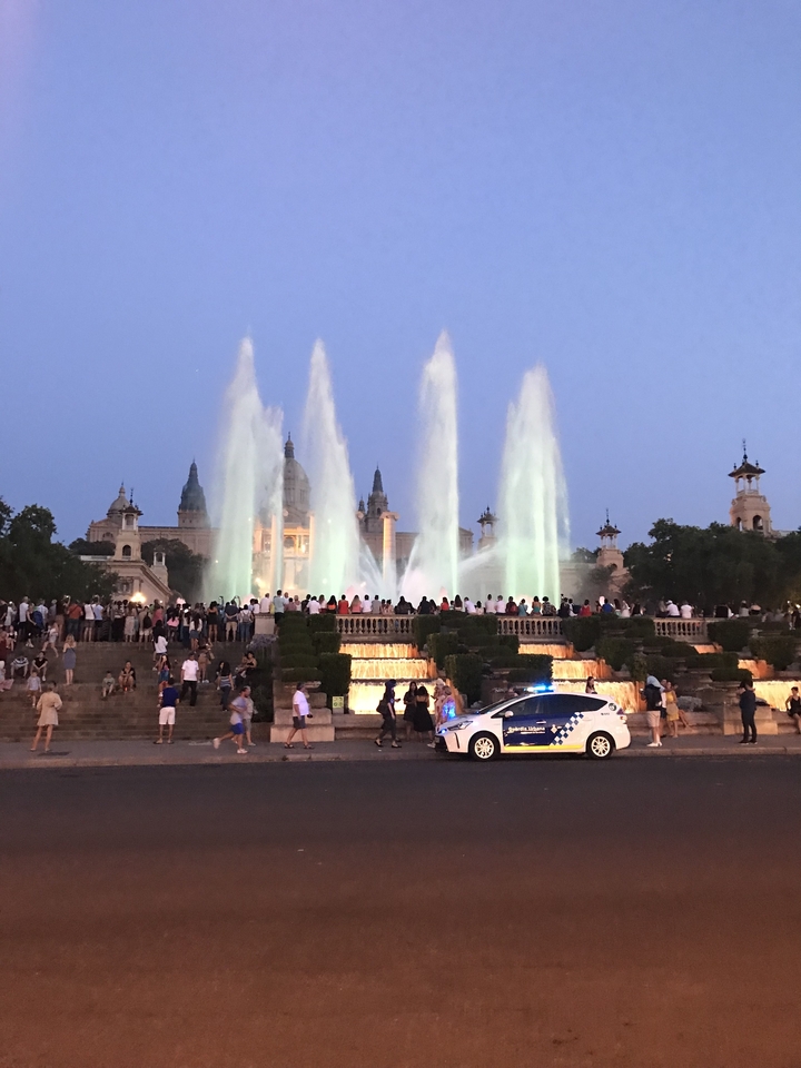 Vue du soir de fontaines et d'un escalier bondé.
