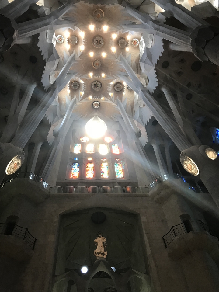 Intérieur de la Sagrada Familia avec vitraux et rayons de soleil.