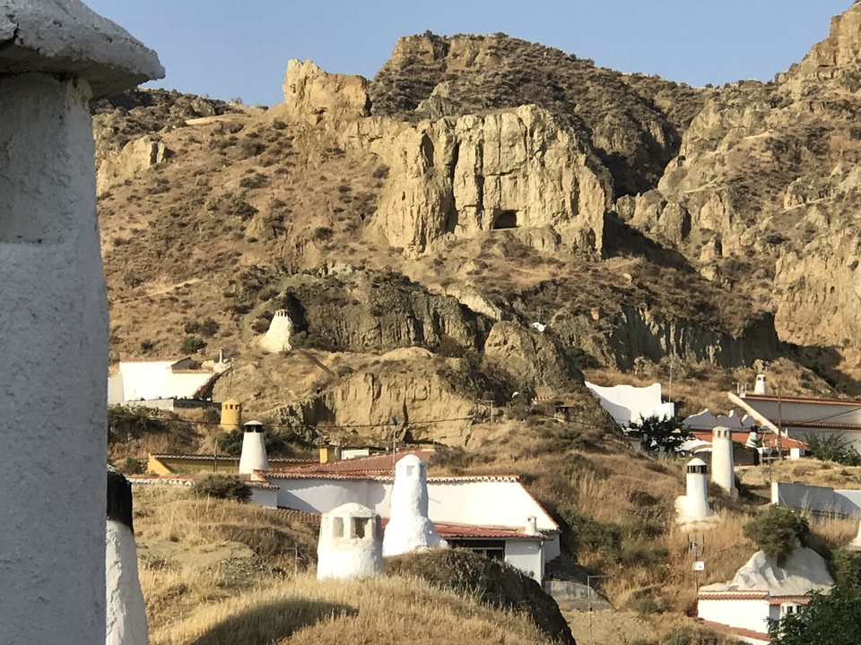 Colline rocheuse avec des bâtiments blancs intégrés.