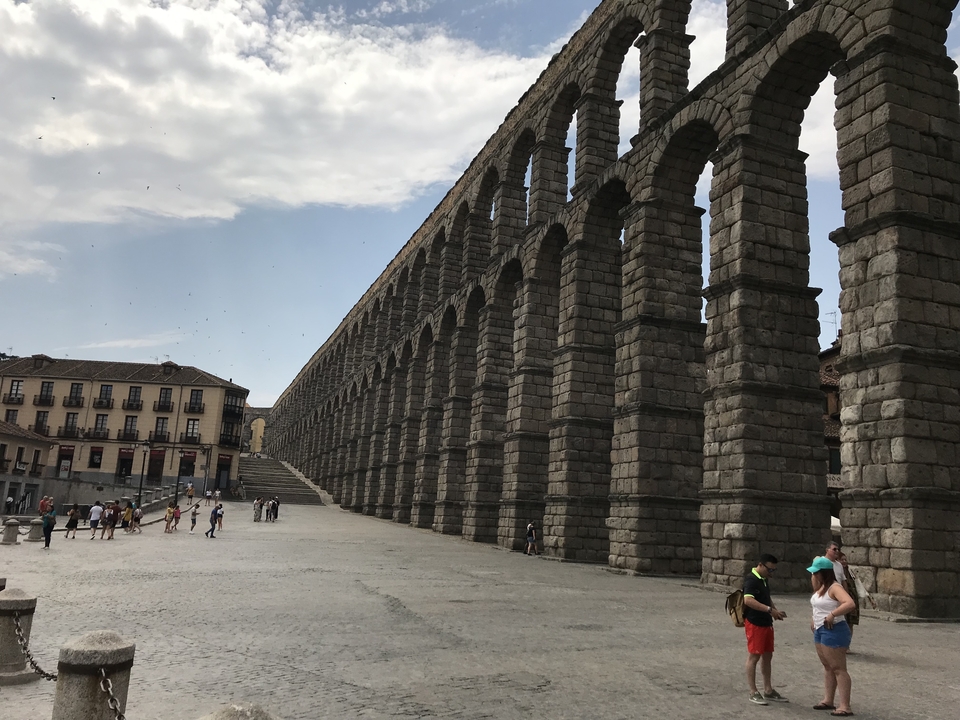 Aqueduc romain avec des personnes qui se promènent à proximité.