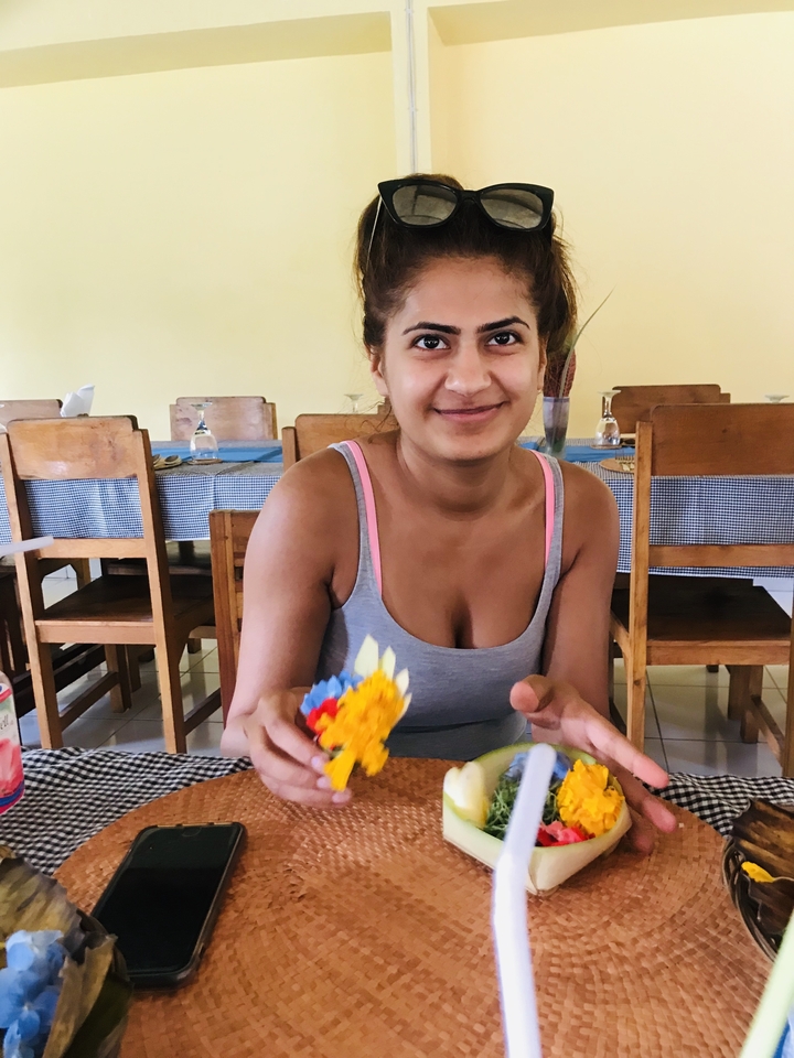Person sitting at a table holding crafted offerings.