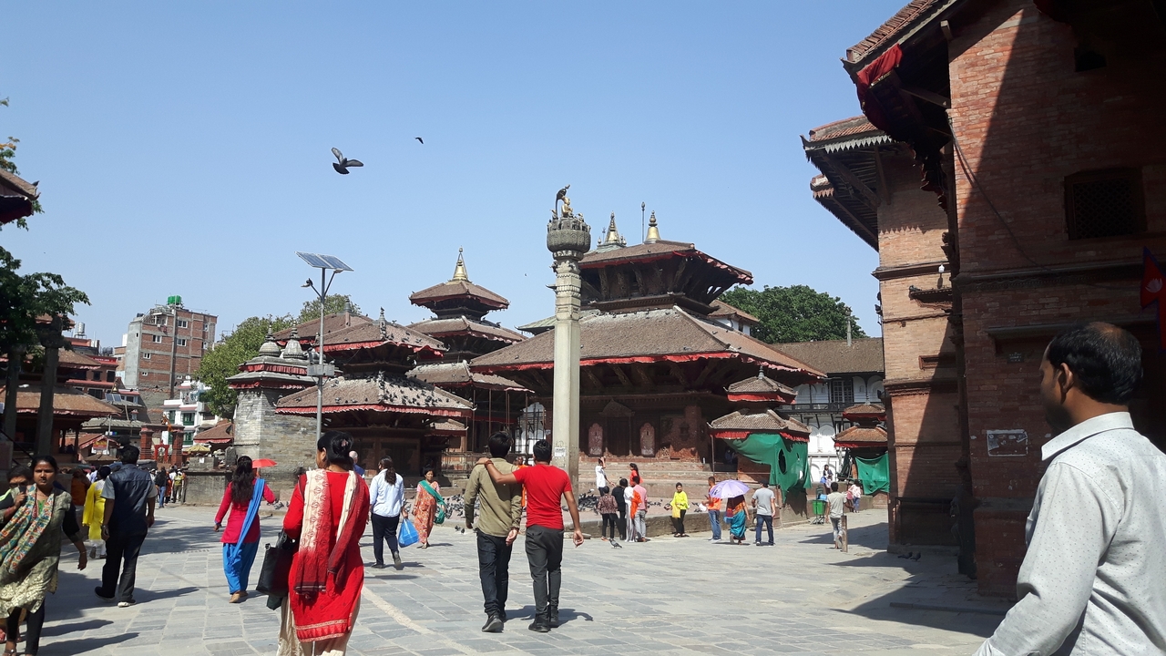 Place historique avec des temples et des gens qui se promènent.