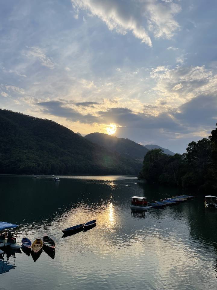 Vue panoramique d'un lac avec des bateaux au coucher du soleil.