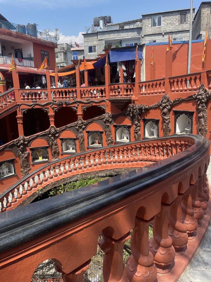 Bâtiment rouge dans une zone de marché bondée avec des sculptures complexes.