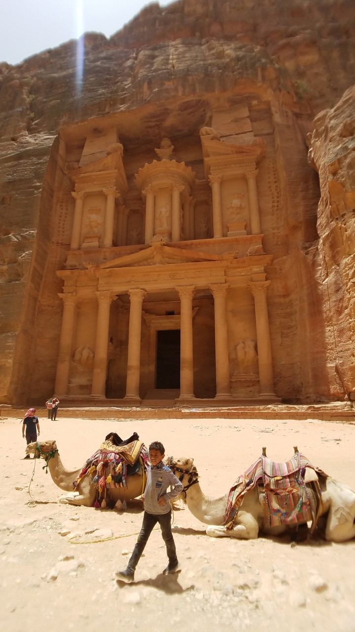 Des gens explorant le Trésor de Pétra, une grandiose façade sculptée.