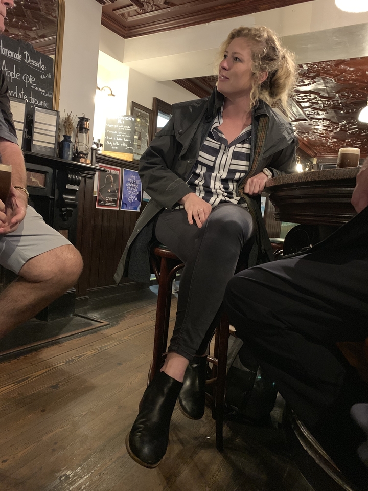 Des personnes assises au bar dans un pub.