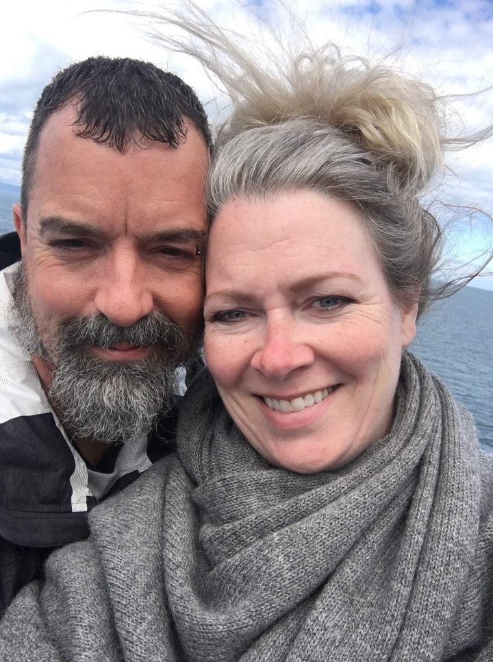 Couple prenant un selfie avec un plan d'eau en arrière-plan.