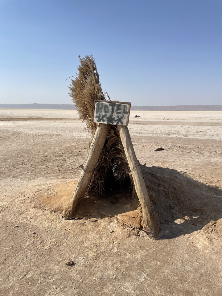 Une petite structure dans un désert étiquetée « Hôtel ».