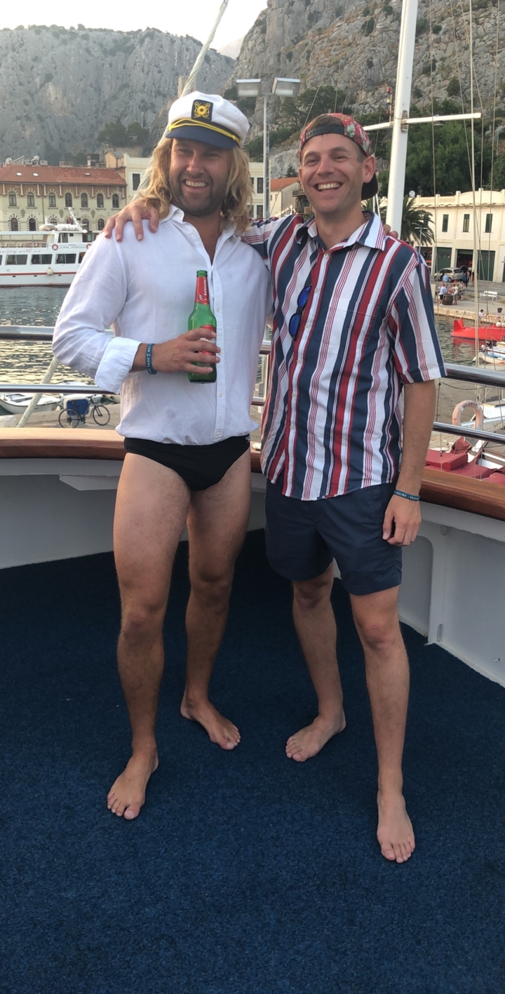 Deux hommes sur le pont d'un bateau, l'un en maillot de bain.