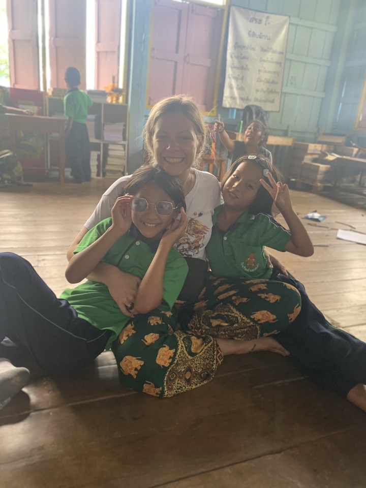 Femme et deux enfants posant à l'intérieur dans une atmosphère chaleureuse.