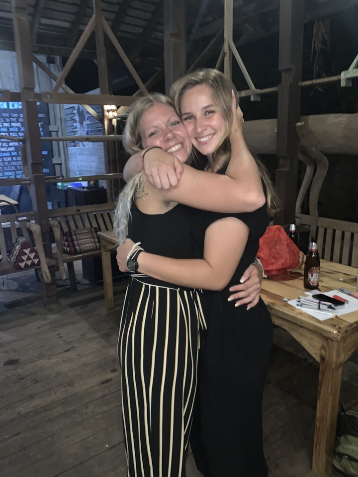 Deux femmes qui s'enlacent et sourient à l'intérieur.