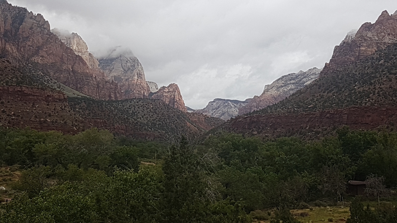 Vue panoramique de montagnes de roche rouge avec de la végétation verte.