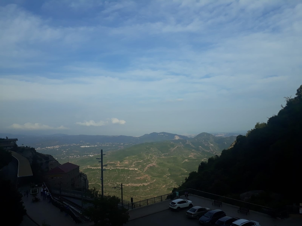 Vue de paysage vallonné avec une route au loin.