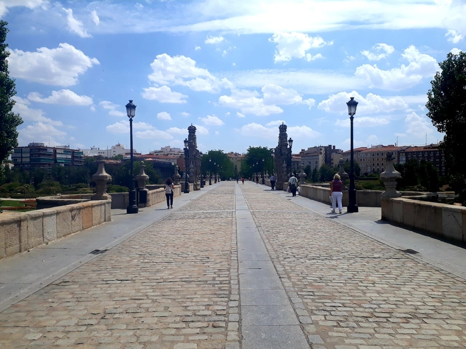 Un large pont piétonnier avec des gens qui marchent et des éléments historiques.