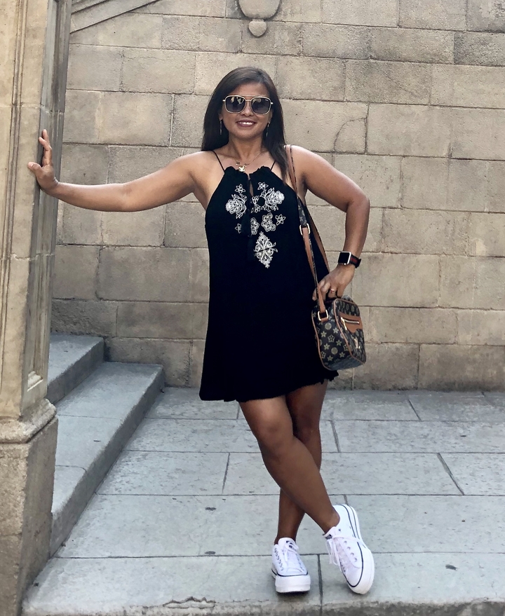 Une femme qui pose contre un mur de pierre avec des marches.