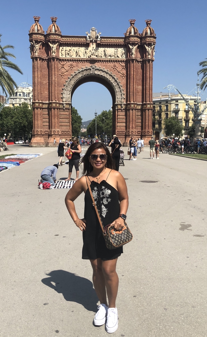 Une femme qui pose devant l'Arc de Triomf.