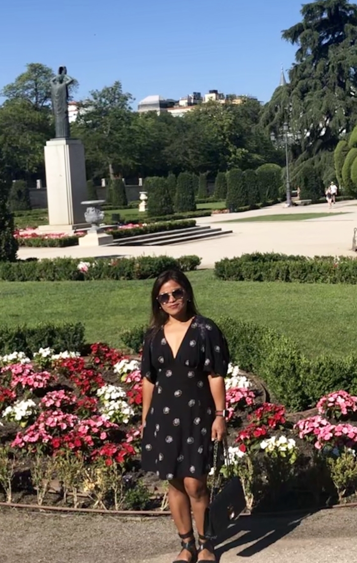 Une personne qui pose dans un jardin bien entretenu.