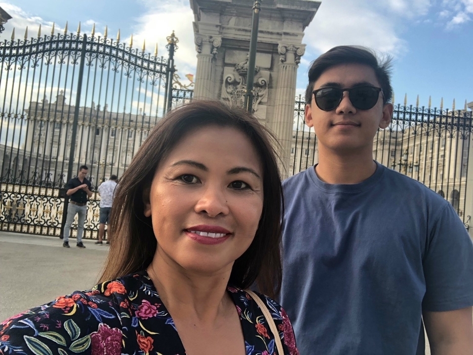 Deux personnes souriantes devant un portail orné.