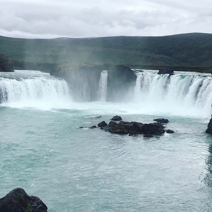 Majestic waterfall surrounded by mist and rocky outcrops.